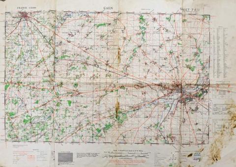 A large beige map with predominantly red and green markings.