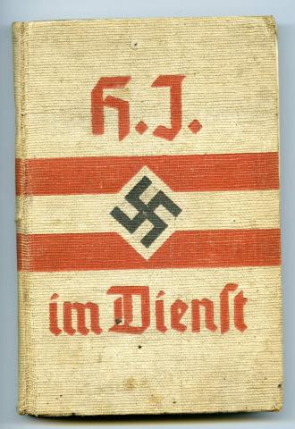 A beige hardcover manual with red writing, two red stripes and a black  swastika in the centre.