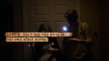 A screenshot of Lottie and Joe using their flashlights to explore the dark storage room.