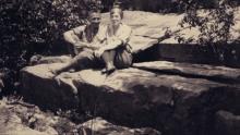 A screen grab of Byron and Mildred sitting beside each other on large rocks