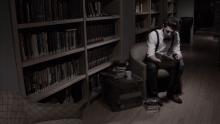 A screenshot of Joe sitting in the library, his chair surrounded by stacks of books.
