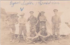 A black-and-white photograph of a group of soldiers posing in front of a tent.