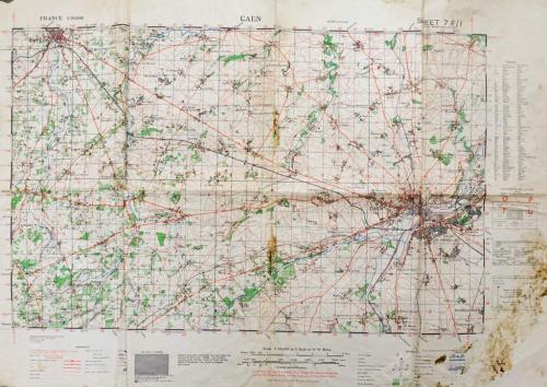 Une grande carte beige avec des inscriptions principalement en rouge  et vert.