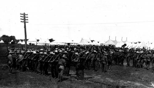 Une photographie en noir et blanc d’un groupe de soldats en rangées durant un entraînement.