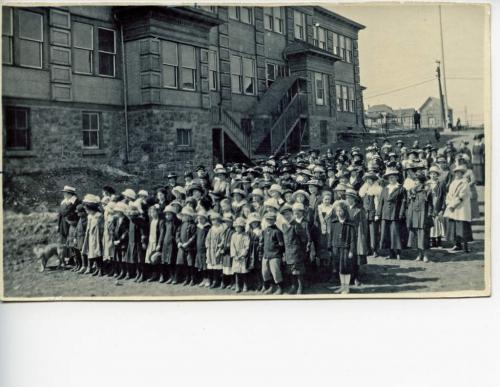 A black-and-white photograph of a large group of volunteers (comprised of women and children).