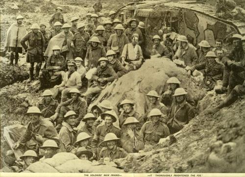 A black-and-white photograph of a group of soldiers posing with a tank.