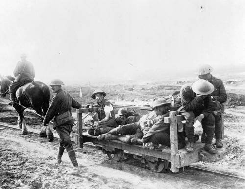 Une photographie en noir et blanc d’une ambulance tirée par des chevaux transportant plusieurs soldats blessés