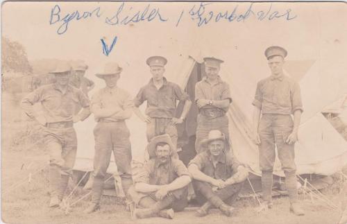 A black-and-white photograph of a group of soldiers posing in front of a tent.
