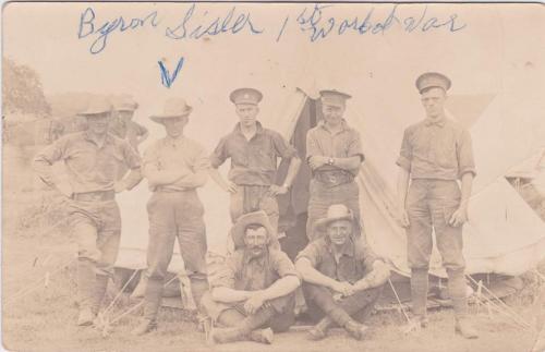 Une photographie en noir et blanc de soldats posant devant une tente.