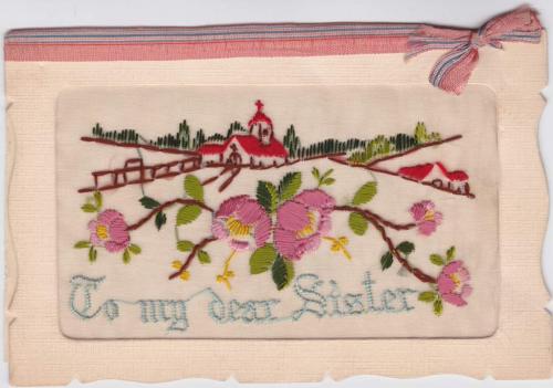 A cloth postcard depicting an embroidered church and house, reading “To my dear Sister.”
