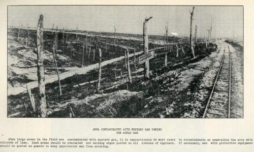 Une photographie en noir et blanc d’un paysage de désolation et d’un panneau avertissant de la contamination au gaz moutarde.