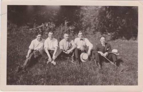 Une photographie en noir et blanc de Byron Cooper Sisler assis avec un groupe d’amis.