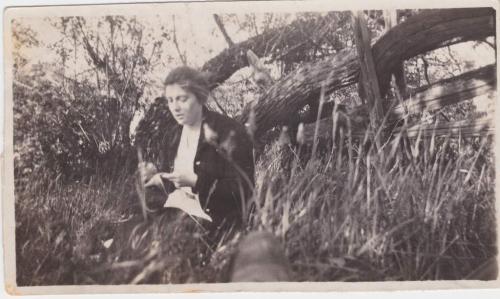 Une photographie de Mildred Sisler assise près d’une clôture de bois.