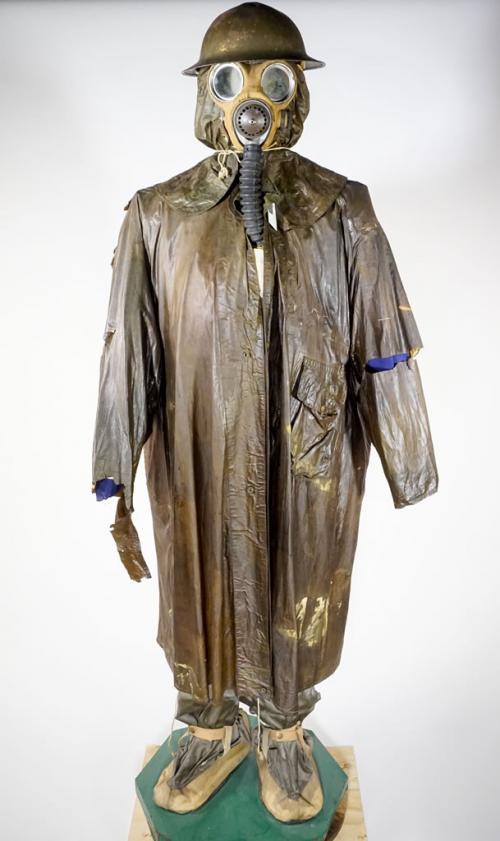 A mannequin wearing a gas mask and a long, heavy rubberized poncho.