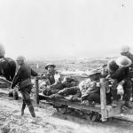 Une photographie en noir et blanc d’une ambulance tirée par des chevaux transportant plusieurs soldats blessés