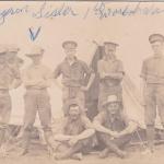 A black-and-white photograph of a group of soldiers posing in front of a tent.