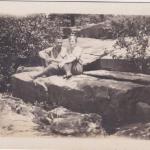 A black-and-white photograph of Byron and Mildred sitting on large rocks.