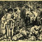 A black-and-white photograph of soldiers with Korean civilians, including a mother and her baby.