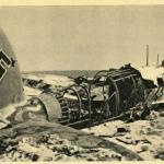 A black-and-white photograph of an airplane crashed on a snowbound landscape.