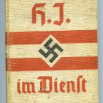 A beige hardcover manual with red writing, two red stripes and a black  swastika in the centre.